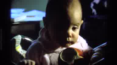 California USA (1977): Alert Baby Girl In Chair Looking Around Rapidly