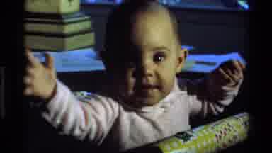 California USA (1977): A Cute Little Baby Is Dancing In The Baby Chair