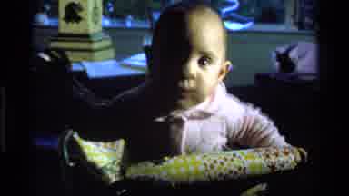 California USA (1977): Getting Babies Attention To Look At Camera As He Learns To