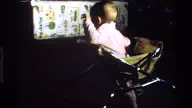 California USA (1977): Baby In Pink Clothes Walking And Housing Towards A Table In