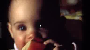 California USA (1977): Infant Being Nursed With Bottle By Elder Woman In Green