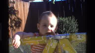 California USA (1977): Baby Standing In A Play Pen Outside In The Bright Sunshine