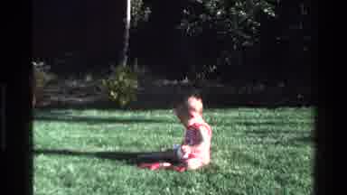 California USA (1977): Baby Sat In Garden Sees Orange Ball And Reaches For It