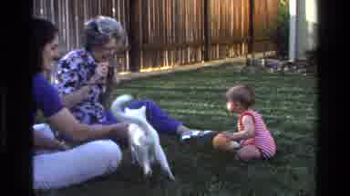California USA (1977): Mom And Baby And Grandmother Sitting On The Grass In A Yard