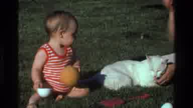 California USA (1977): The Child Is Playing With The Ball And The Cat Is Lying In