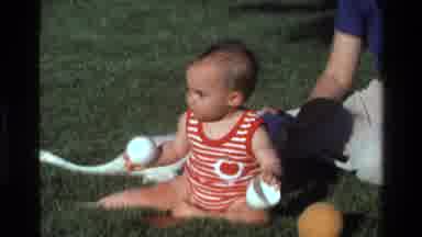 California USA-1977: Baby Girl Playing On Grass With Teacups