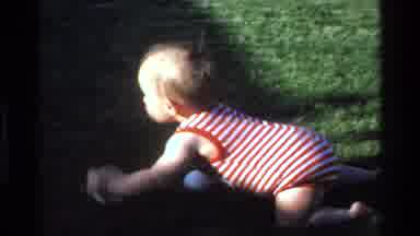 California USA (1977): A Child Is Moving Forward Towards Mother In A Garden
