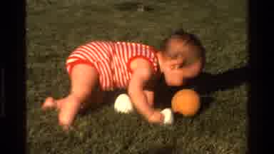 California USA (1977): Baby Boy Playing With A Little Ball On The Grass