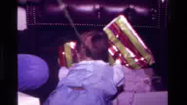 California USA (1977): Baby Boy Crawling Towards Wrapped Presents With Father