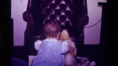 California USA (1977): A Small Child Sits A Stuffed Bear Down And An Adult's Hand