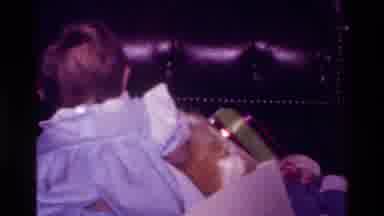 California USA (1977): A Baby Girl Opening Presents And Mom Picks Up Baby