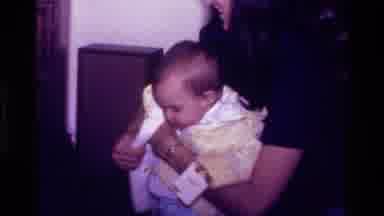 California USA (1977): Woman Holding Baby Boy And Putting His Coat On Him