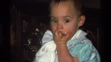 California USA (1977): Baby Eating And Having Fun With A Rubber Band In An Old