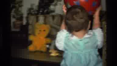 California USA (1977): Adorable Little Girl Chewing On Toy And Throwing Red Ball