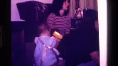 California USA (1977): A Baby Walking Around And Playing With Gift Wrap Paper And
