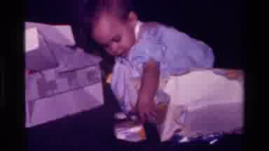 California USA (1977): A Child Is Taking Boxes And Standing