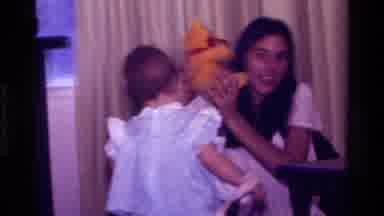 California USA (1977): Baby Toddler Girl Carrying Something Yellow Walking Toward