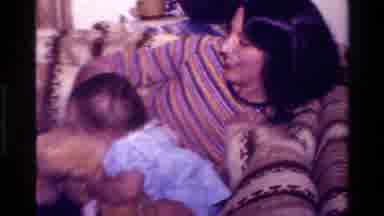 California USA (1977): Mother And Baby Playing With A Teddy Bear In The Family