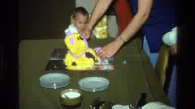 California USA (1977): A Little Baby Girl Watching People Cut And Eat Their