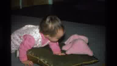 California USA (1977): A Baby Sits On A Mat Of Sinza Color Falling Over A Pillow