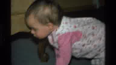 California USA (1977): Baby Girl In A Yellow Coat At Home With The Family Dog