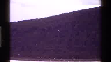 KENYA-1983: Boat Ride View Of Hill By The River With Birds Flying Above