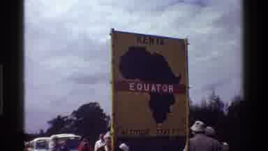 KENYA-1983: Children Play Outside Near Equator Sign In Color On Cloudy Day