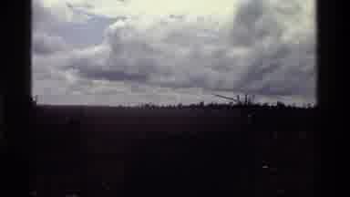 Kenya (1983): Camera Zooms In On A Small Hut In A Field Two Men Walk By Destroyed