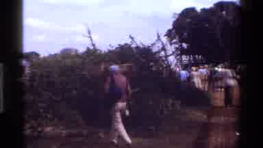 Kenya (1983): Older Man Strays Away From Crowd To Hide Behind Bushes