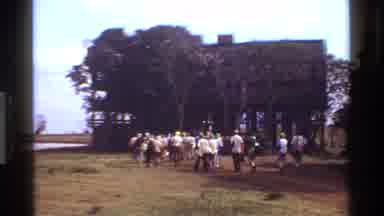 Kenya (1983): On A Grassy Plain People Walk Towards A Rustic Building And Ascend