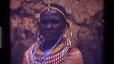KENYA-1983: A Maasai Woman In Traditional Beaded Jewelry And Rural Dwelling