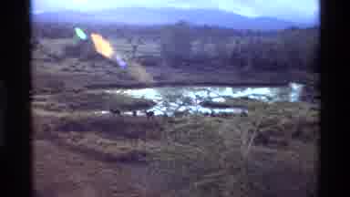 Kilaguni Kenya (1983): A Lake In The Middle Of A Green Vegetation With A Mountain