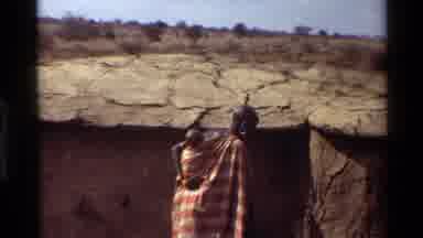Kilaguni Kenya (1983): African Woman Carrying Baby Inside Her House