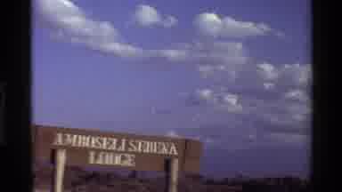 Mara Tanzania (1983): Sky And Landscape Above Amboseli Serena Lodge Wooden Sign
