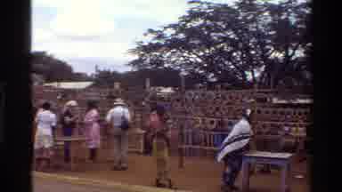 Mara Tanzania (1983): Man Talking With Woman And Baby At Colorful Textile Factory