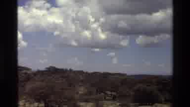 Mara Tanzania (1983): Clouds Over A Blue Sky In A Desert Like Terrain On A Sunny