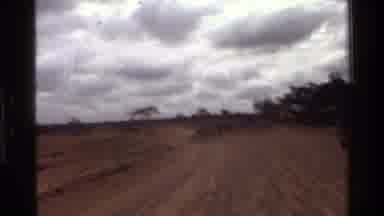 Mara Tanzania (1983): A Dirt Road And Three People Walking Towards Their Unknown