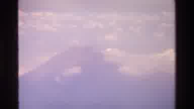 Singapore (1984): Large White Clouds Surrounding A Tall Brown Mountain Top During