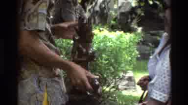 Singapore (1984): Men Showing Tourist Merchandize To Buy