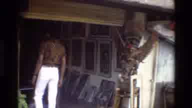 Singapore (1984): Person Visiting A Vintage Shop With Arts On Floor And Wall