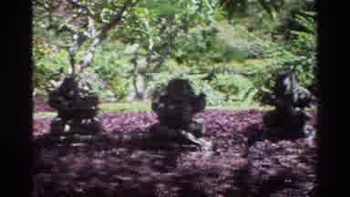 Singapore (1984): Four Statues In A Garden Surrounded By Purple Flowers And Trees