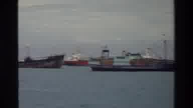 Singapore (1984): Many Cargo Ships In A Port With Rolling Waves On A Cloudy Day