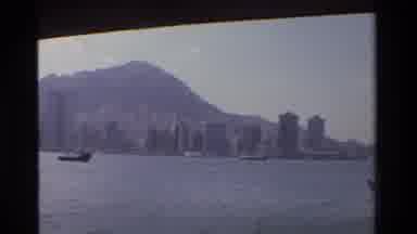 Hong Kong (1984): Panning A Coastline With Large Buildings And A Mountain In The