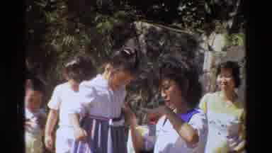 Hong Kong-1984: Mother Adjusting Daughter's Dress in Outdoor Family Scene
