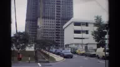 Thailand (1984): Cars Parked On Busy City Street Up To Yellow Crane Actively