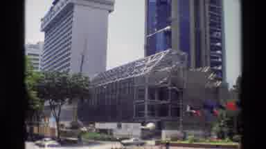 Thailand (1984): A Couple Of Large White And Brown Buildings In A City