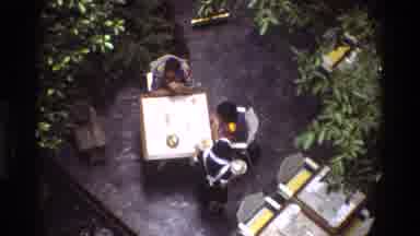 Thailand (1984): Viewed From Overhead A Female Maid Serves Two Dining At A Square
