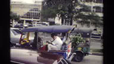 Thailand (1984): People Driving In A Car On The Street With Plenty Of Different