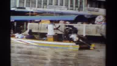 Thailand (1984): Man Reads Newspaper Yellow And Blue Boats Docked On A Clear Sunny