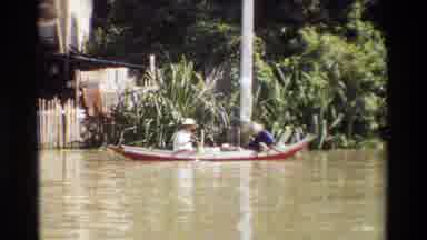 Thailand (1984): Two Men Sit On A Canoe Then We See Children Standing By The River
